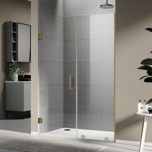 Frameless sliding shower door with brushed gold hardware and clear 10mm tempered glass installed in a modern bathroom with neutral tile and open layout